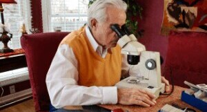 Man looking through microscopes in an office setting